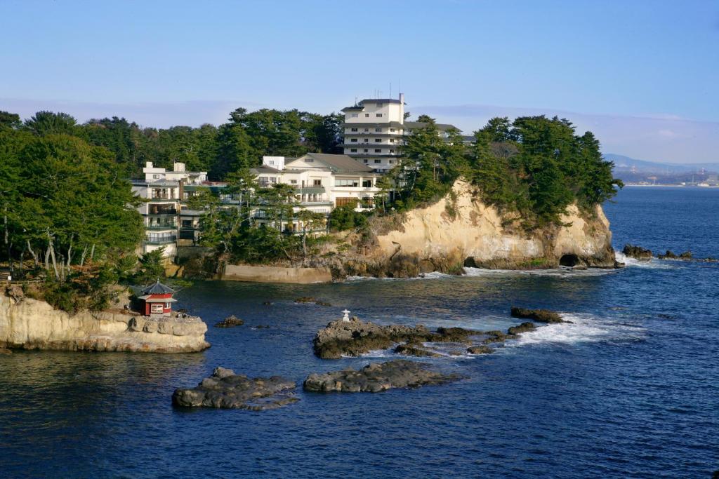 a group of houses on an island in the water at Itsuura Kanko Hotel in Kitaibaraki