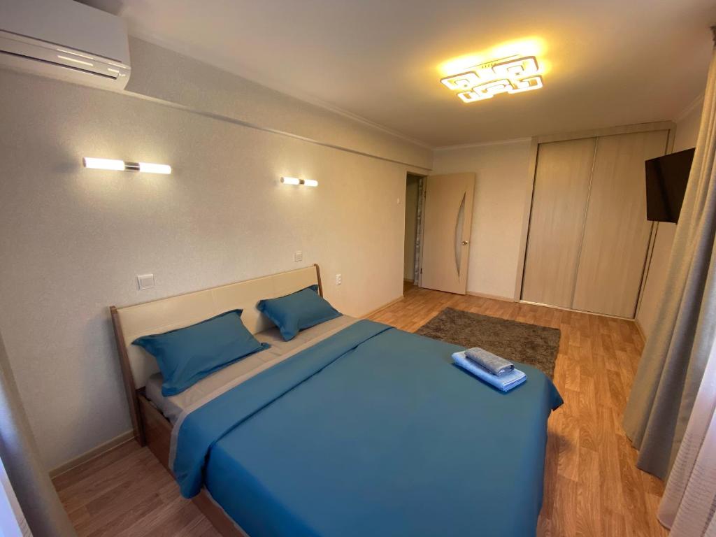 - une chambre avec un grand lit bleu et des oreillers bleus dans l'établissement Апартаменты Балхаш, à Balkhach