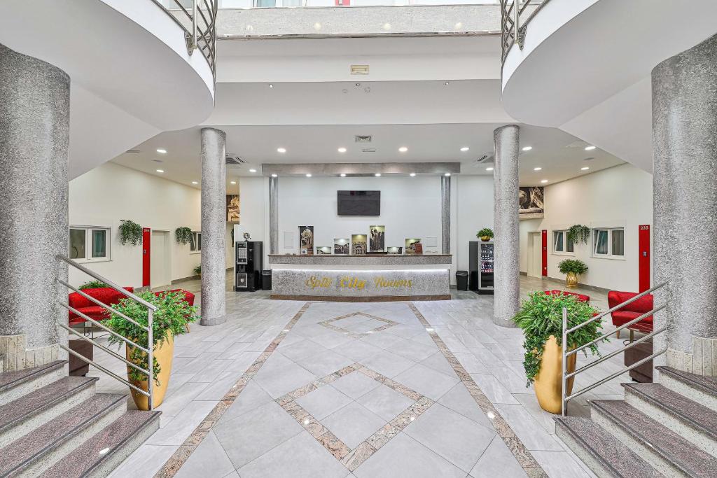 a lobby of a hotel with pillars and a counter at Split City Rooms in Split