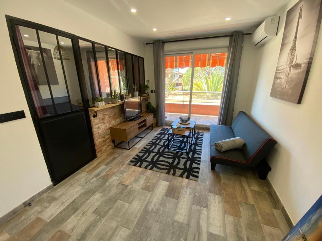 a living room with a couch and a television at appartement vue mer avec place de parking privée in Sainte-Maxime