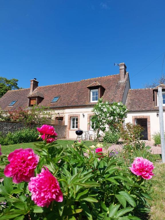 a house with pink flowers in front of it at Les Clématites, maison de campagne. in Boissy-lès-Perche