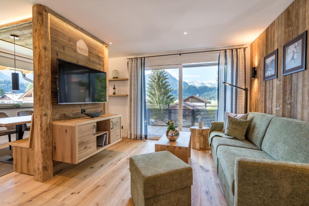 a living room with a couch and a tv at Dorf Suites in Oberstdorf