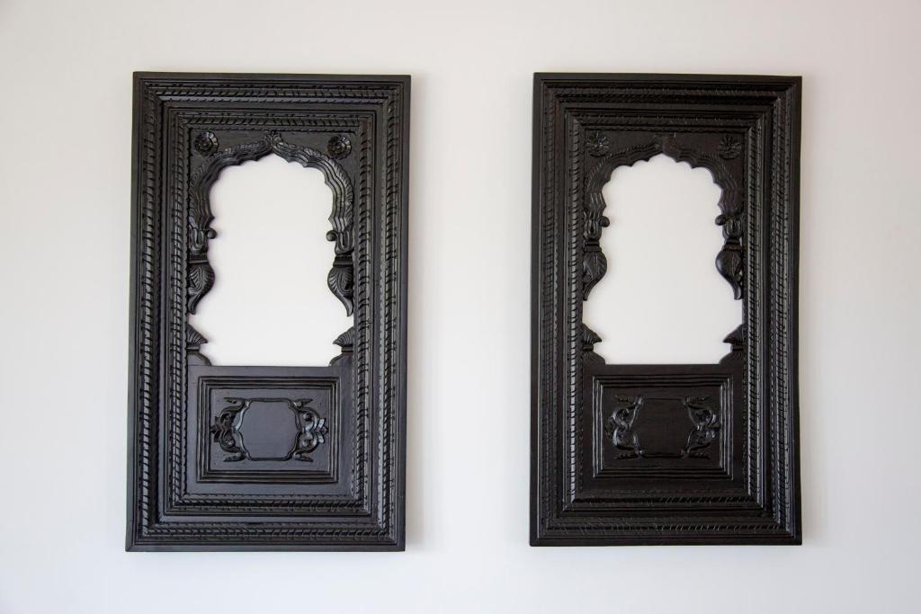 two black framed mirrors on a white wall at Arabella on Boossa in Galle
