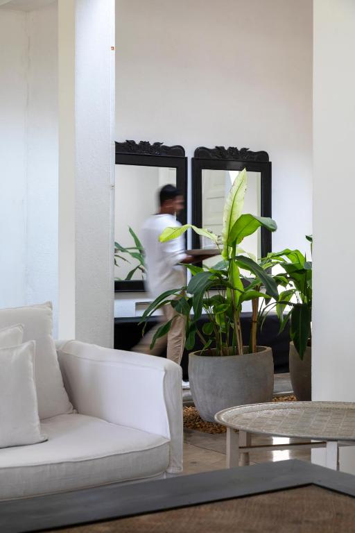 a living room with a white couch and a man in a mirror at Arabella on Boossa in Galle