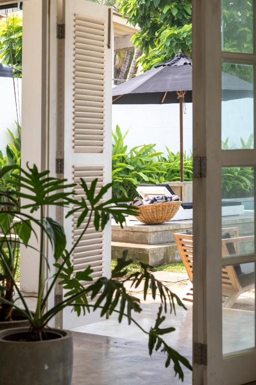a house with a potted plant and an umbrella at Arabella on Boossa in Galle