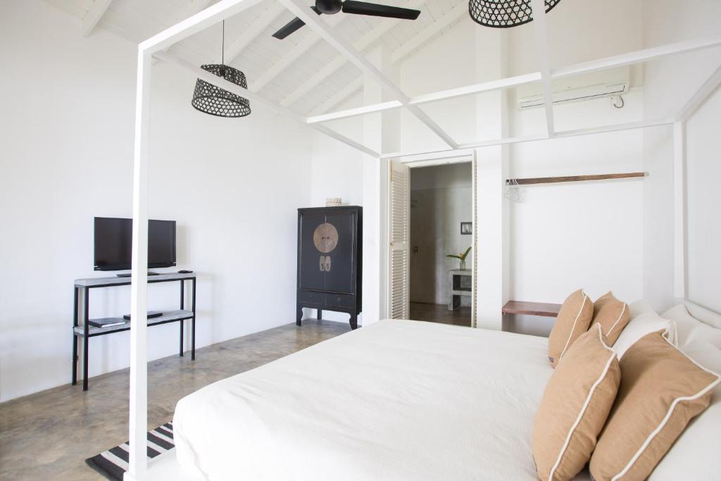 a white bedroom with a bed and a tv at Arabella on Boossa in Galle