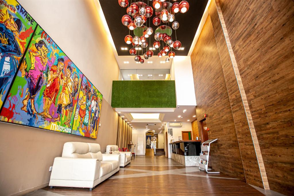 een lobby met witte meubels en schilderijen aan de muur bij Chulia Mansion in George Town