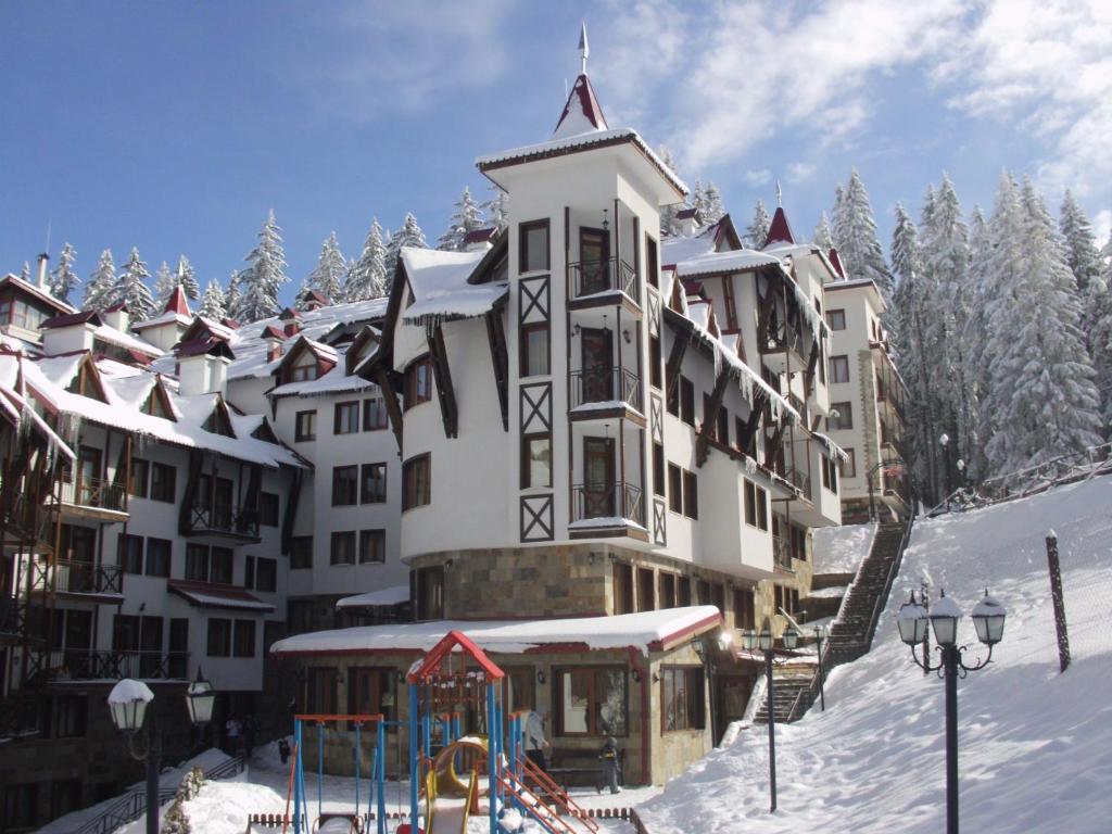 un gran edificio con un parque infantil en la nieve en The Castle Complex - Apartment 401 en Pamporovo