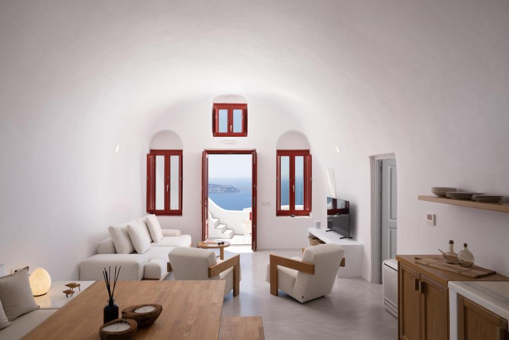 a living room with white walls and white furniture at Serendipity Cliffside Villa & Suites in Imerovigli