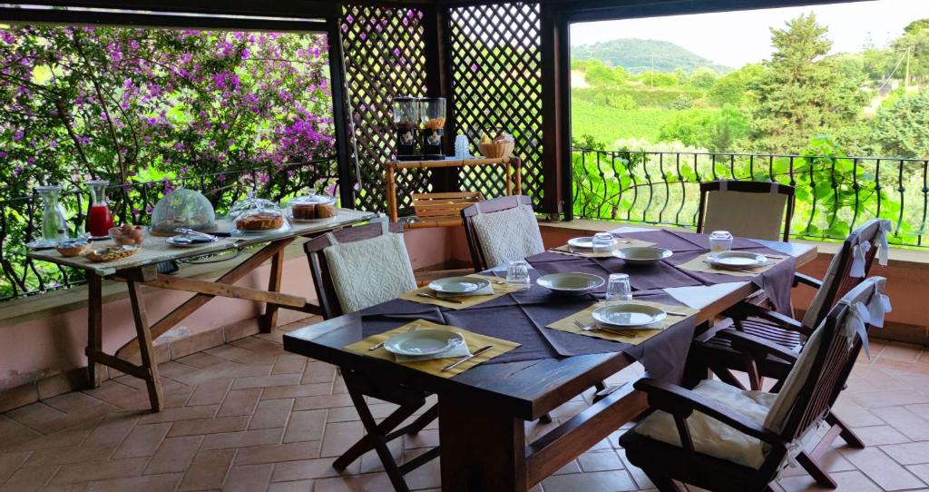 un tavolo e sedie in legno su un patio di La Tinaia Country House a Magomadas