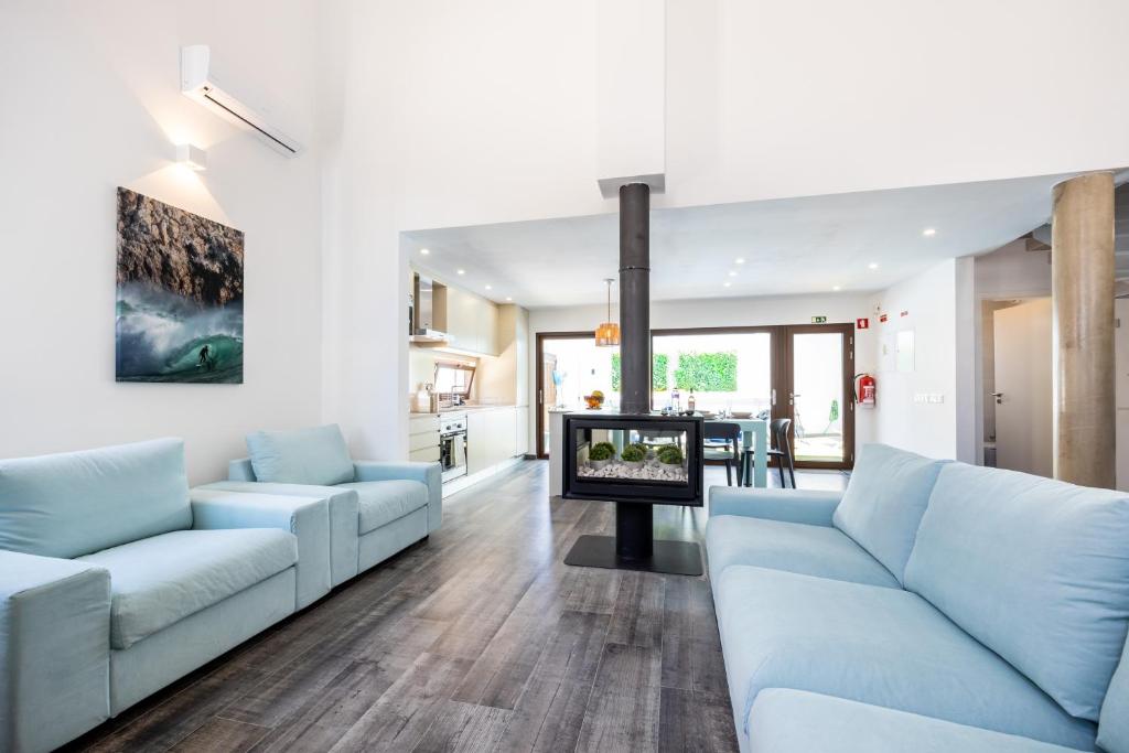 a living room with blue couches and a tv at Casa da Vuvu Montes de Alvor in Alvor