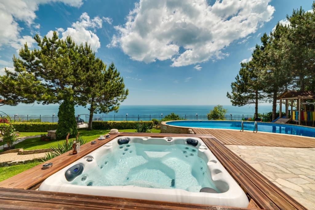 d'un bain à remous au milieu d'une terrasse avec une piscine. dans l'établissement Sunny House Izgrev, à Balchik