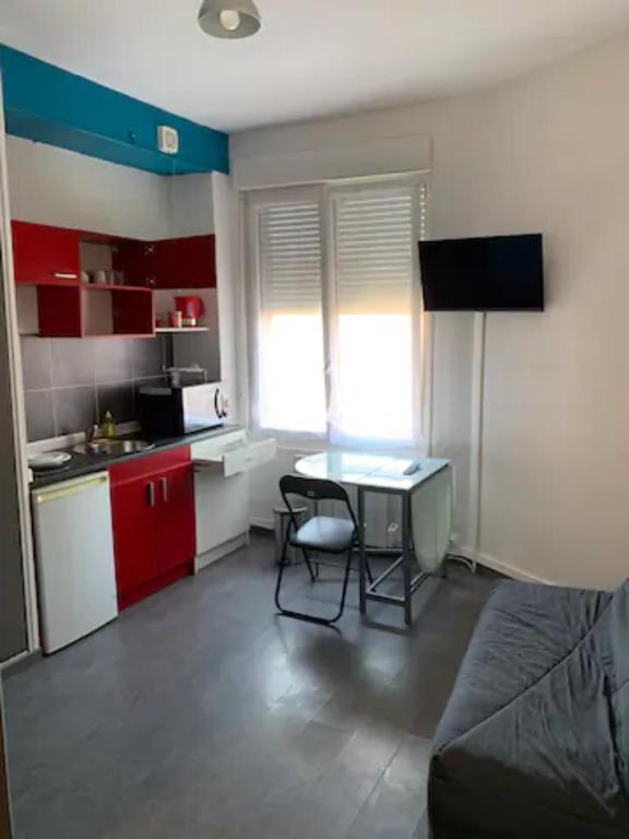 une petite pièce avec une table et une cuisine dans l'établissement Studio 1 tout confort Avec wifi et Netflix, à Valenciennes