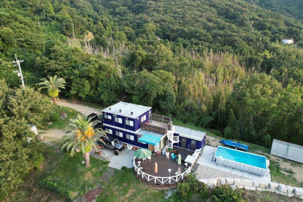 eine Luftansicht eines blauen Hauses inmitten eines Waldes in der Unterkunft 1棟貸し tbtランド 定員最大12名 in Shodoshima