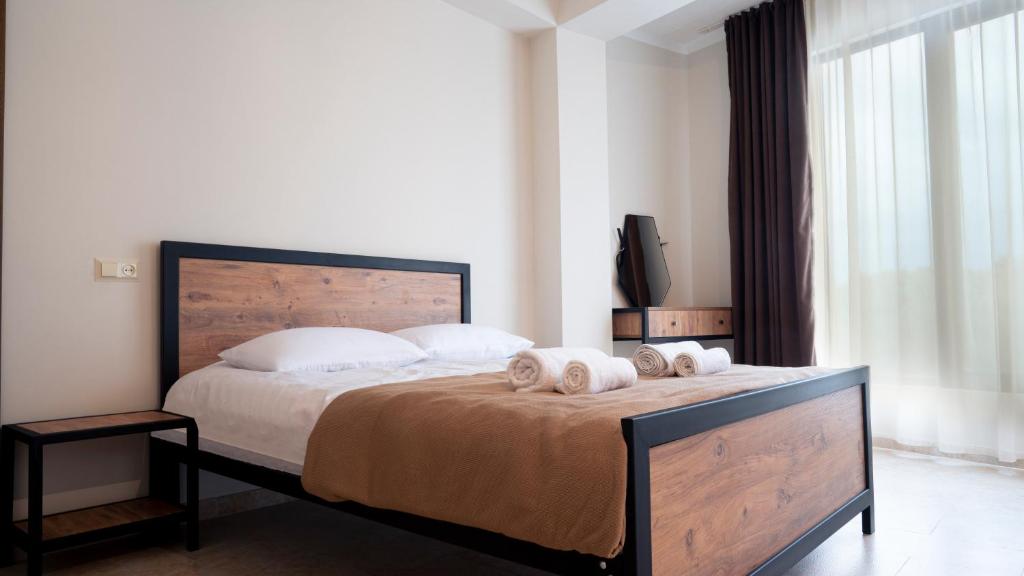 een slaapkamer met een bed met twee handdoeken erop bij Babilon Hotel Tbilisi in Tbilisi City