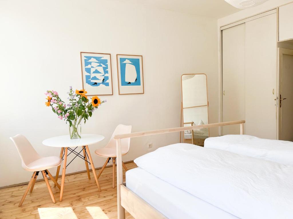 um quarto com duas camas e uma mesa com um vaso de flores em Central Apartment next to Belvedere Castle em Viena
