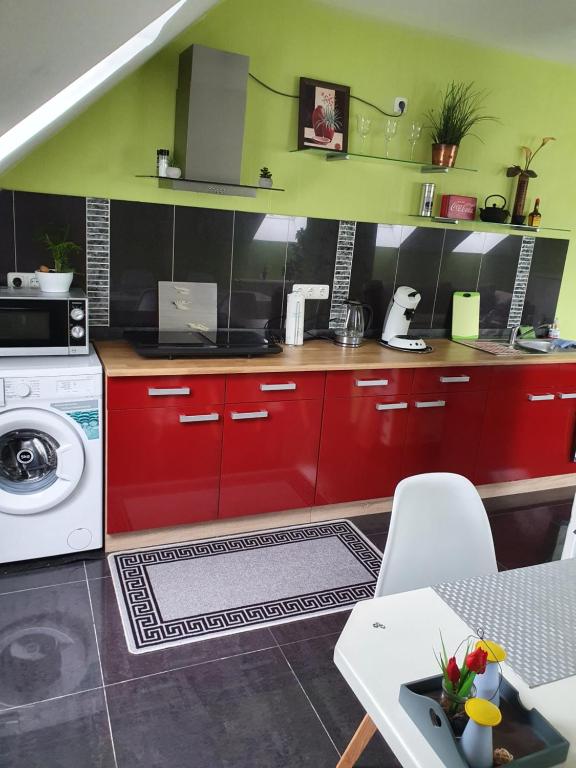 cocina con armarios rojos y lavadora en Apartment am Obenende, en Papenburg