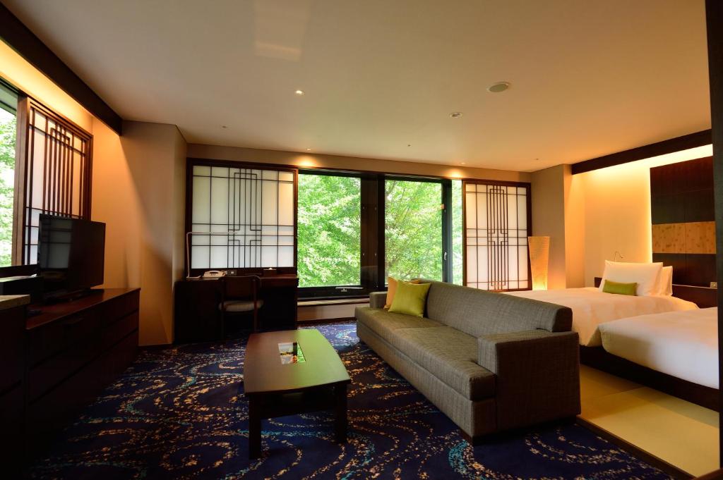 a hotel room with a bed and a couch and a television at Hotel Ryumeikan Ochanomizu Honten in Tokyo