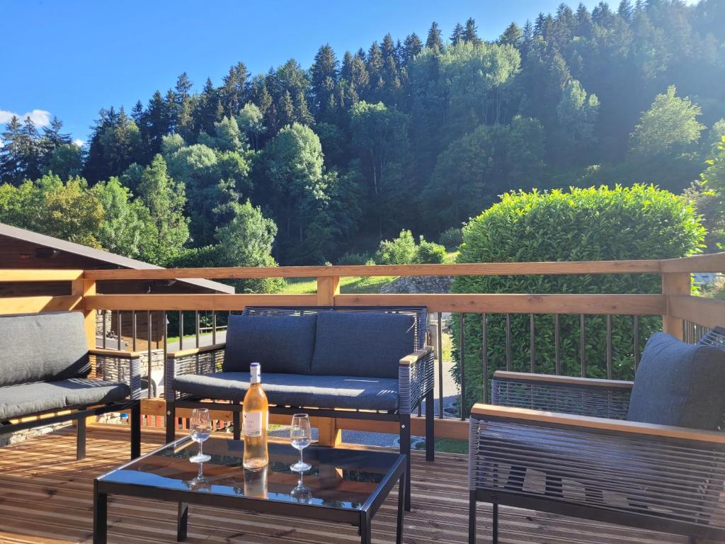 a patio with two chairs and a bottle of wine on a table at gîteduruisseau73, maison entière 80m2 au calme, 2 chambres 2 salles de bain avec terrasse et garage in Bourg-Saint-Maurice