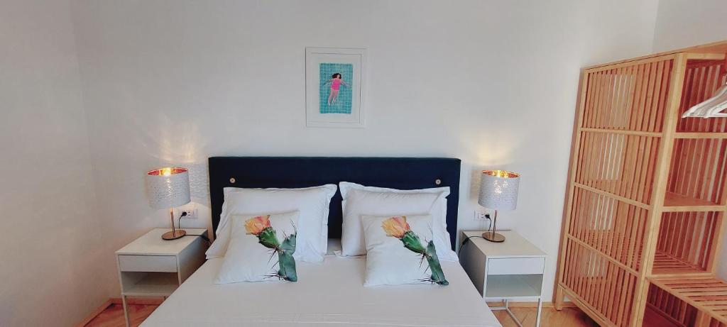 una camera con un letto con due cuscini e due lampade di Vila Luka a Hvar