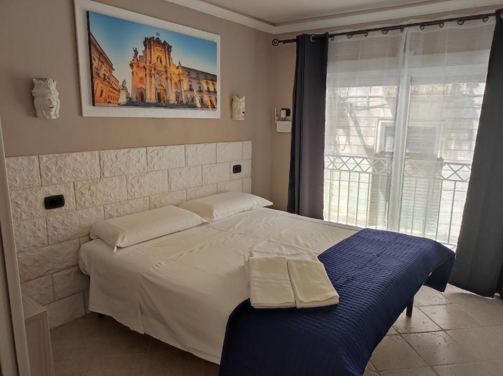 a bedroom with a large bed with a window at Al Settimo porta marina in Syracuse