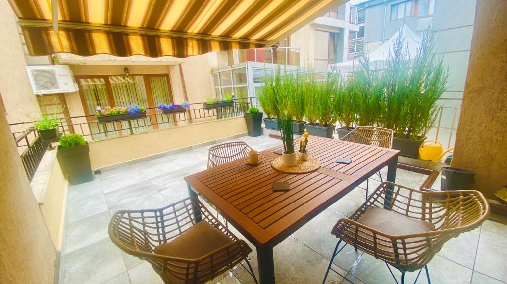 d'une terrasse avec une table et des chaises en bois. dans l'établissement Burgas apartment, à Bourgas