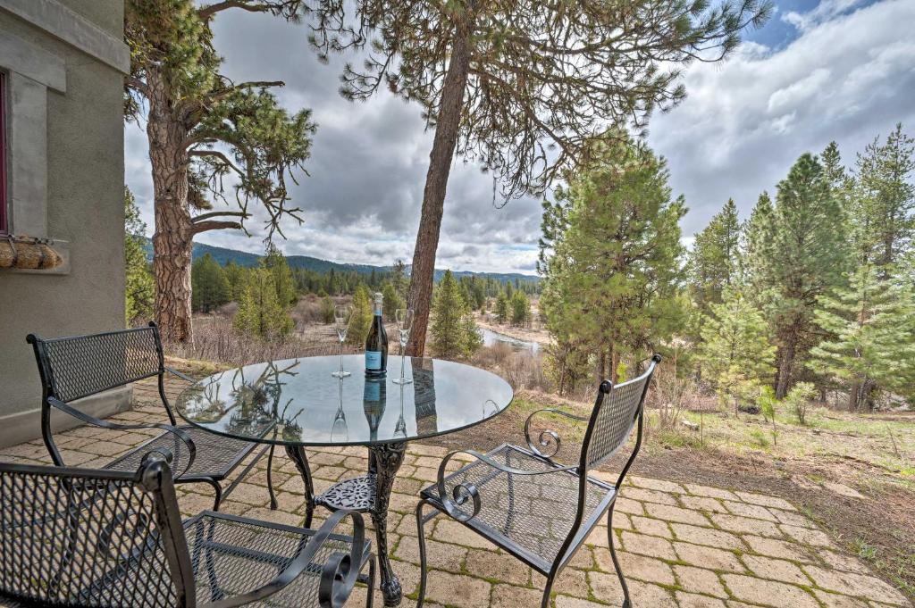 a patio with a glass table and chairs and trees at Private McCall Apartment with Mountain View! in Donnelly