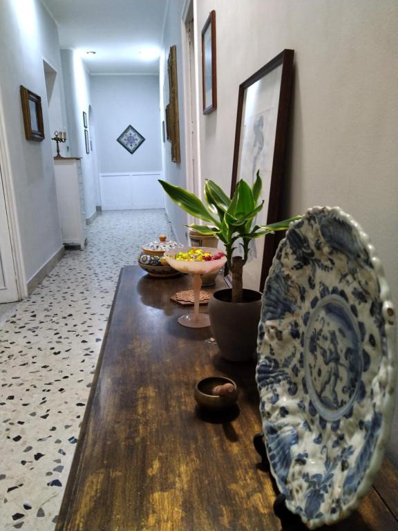 a living room with a table and a plant at Il Genio del Porto - Mabbonath b&b in Palermo