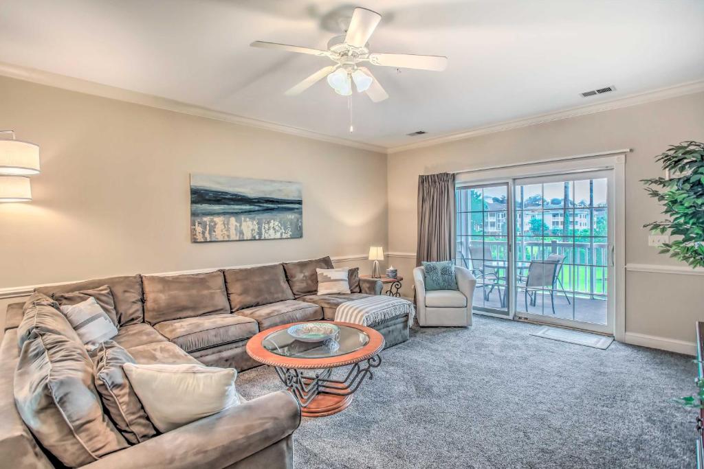 a living room with a couch and a table at Sunny Myrtlewood Condo with Golf and Pool Near Beach! in Myrtle Beach