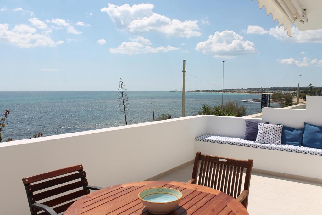 a table and chairs on a balcony with the ocean at Casa fronte mare a Torre Vado 2 in Torre Vado