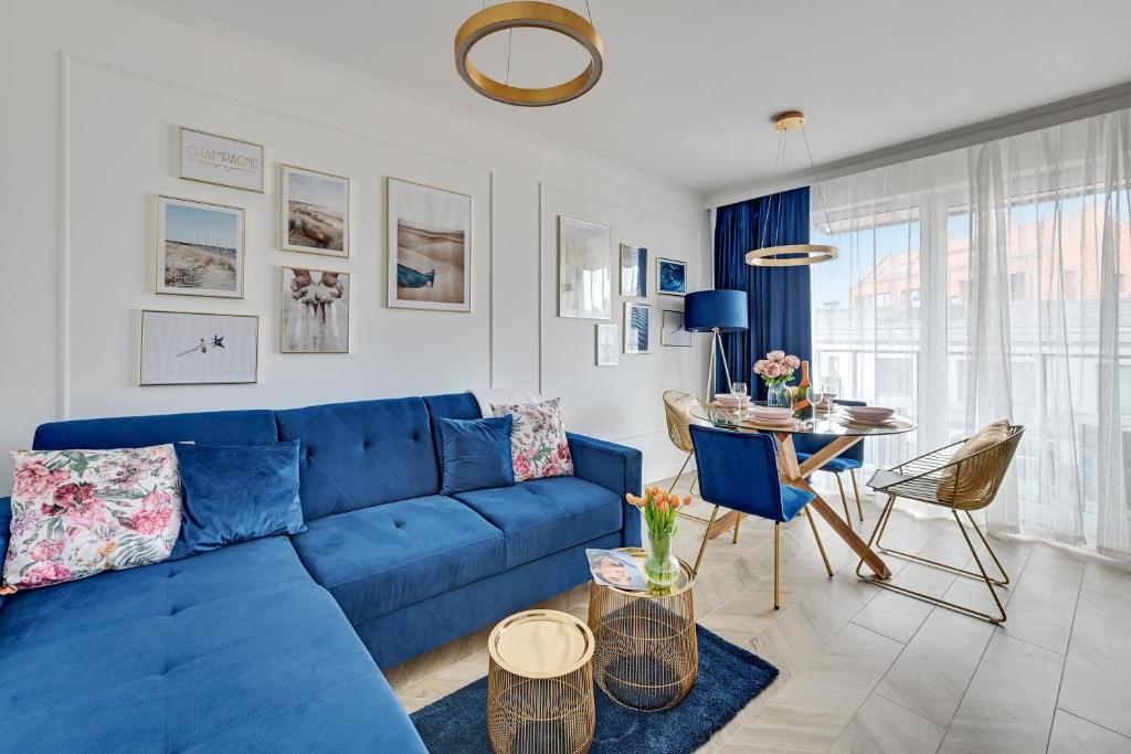 a blue couch in a living room with a table at TriApart Apartment Angielska Grobla DeLux in Gdańsk