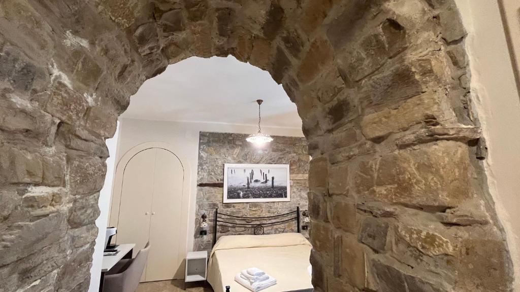 Pokój z łóżkiem w kamiennej ścianie w obiekcie Locanda Badia Residenze Iride e Celeste w mieście Castellabate