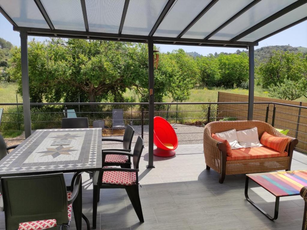 un patio avec une table et des chaises sur une terrasse dans l'établissement maison grysélienne, à Gréoux-les-Bains