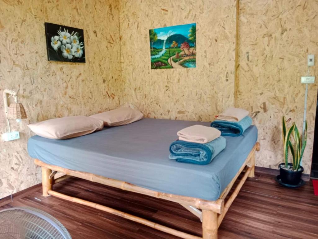 a bed in a room with two towels on it at Imsuk Bo Klua in Ban Pha Khap