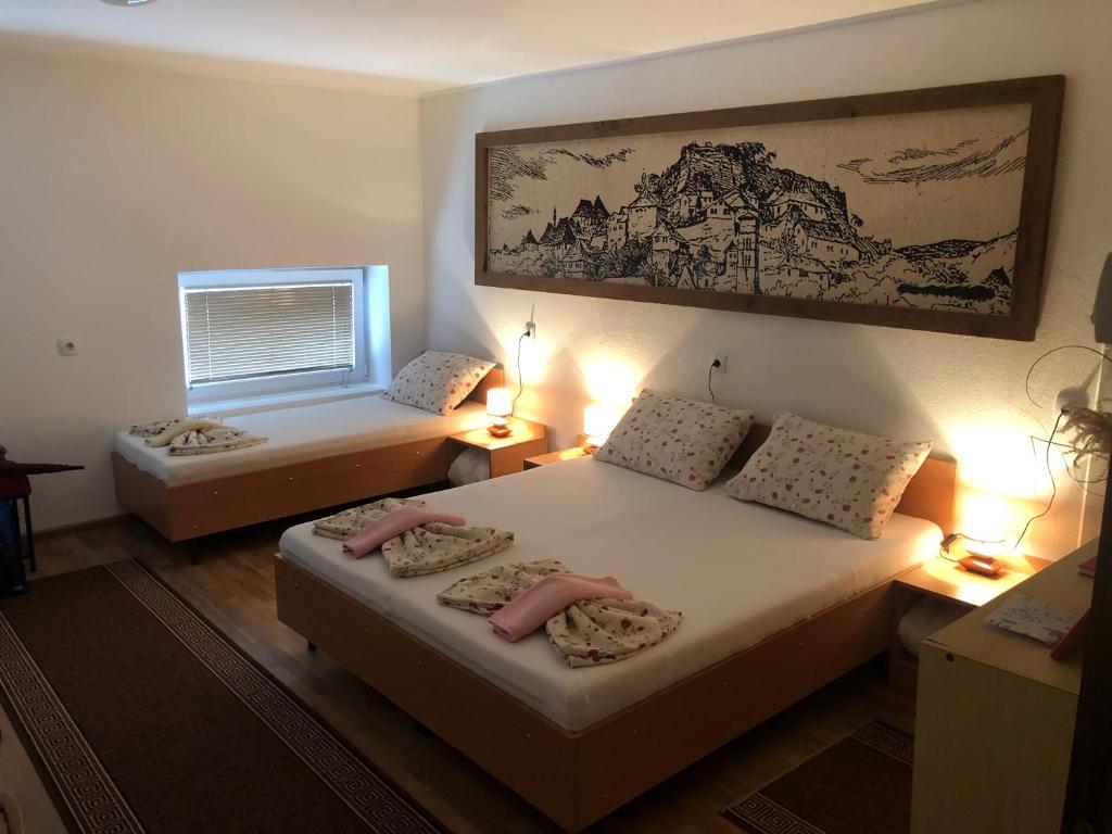 Habitación pequeña con 2 camas y ventana en Prenoćište Gany, en Jajce