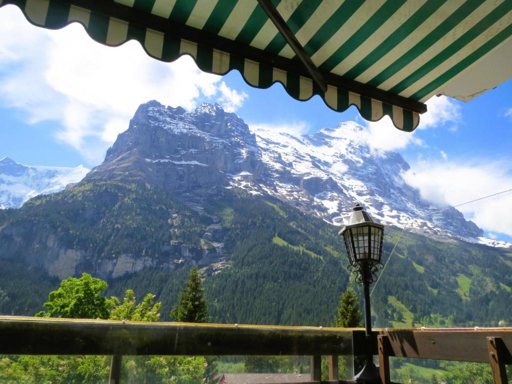 einen Bergblick von einem Tisch mit einem Regenschirm in der Unterkunft Bernerhof Residence in Grindelwald
