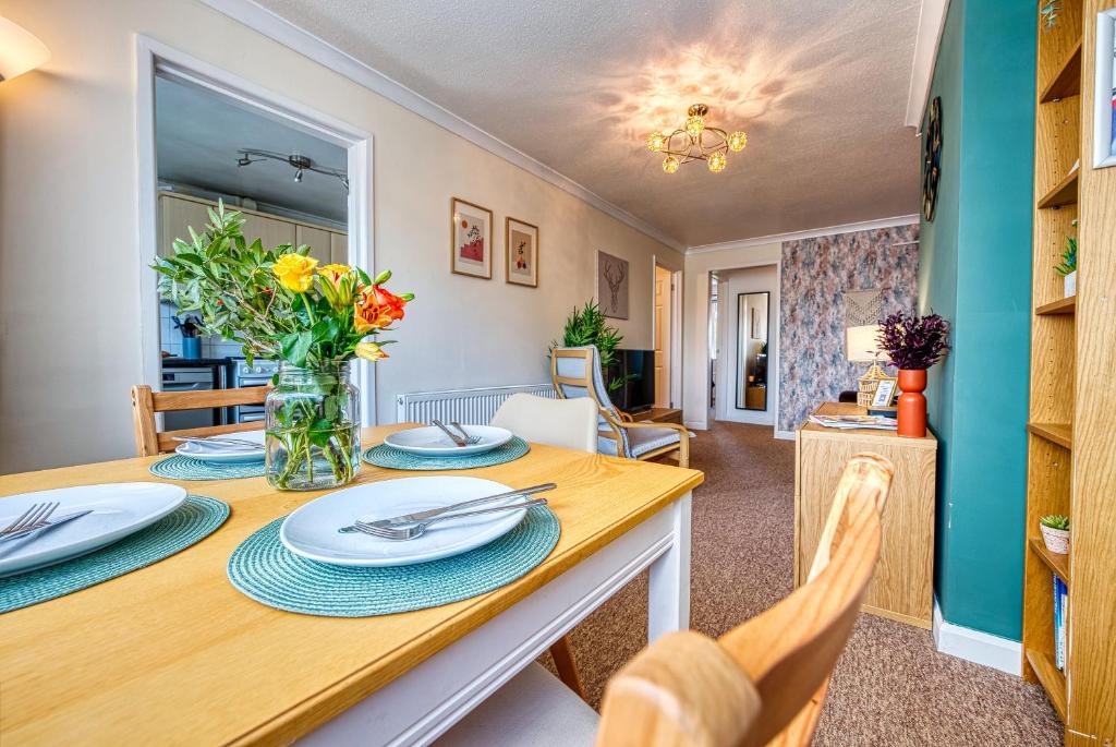 a dining room and living room with a table and chairs at Cosy 3 bed apartment in Southam, sleeps 6 in Southam