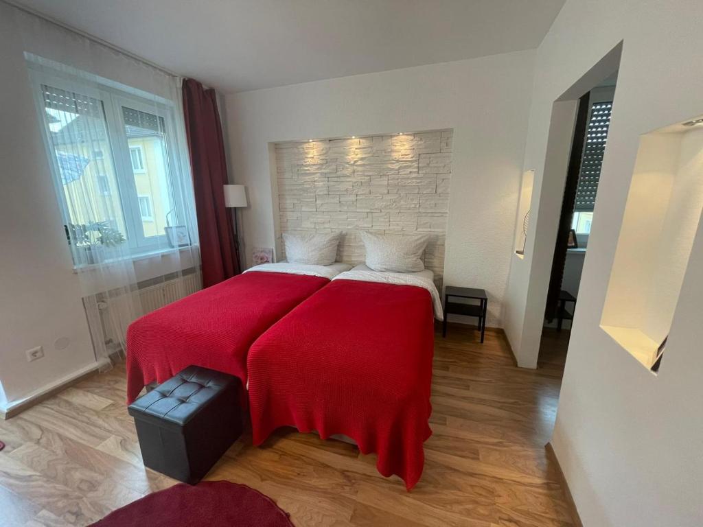 a bedroom with two beds with red blankets at Rose No 4 in Friedrichshafen