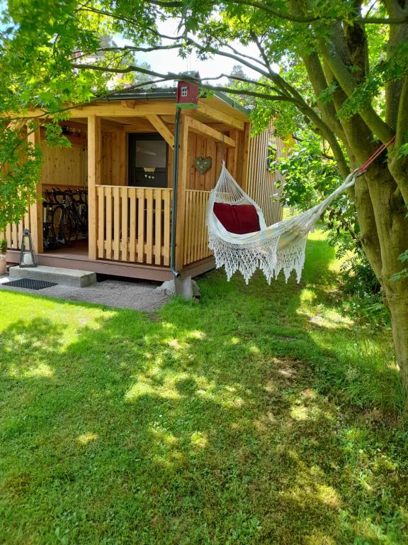 una hamaca frente a una cabaña en un patio en Ferienhaus Helmig, en Kurort Gohrisch