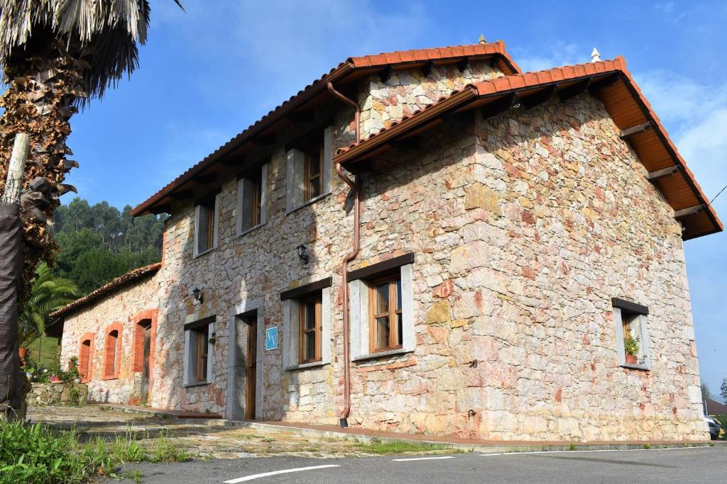 an old stone building with a red roof at Casa Carmen y Mera in Ferroñes