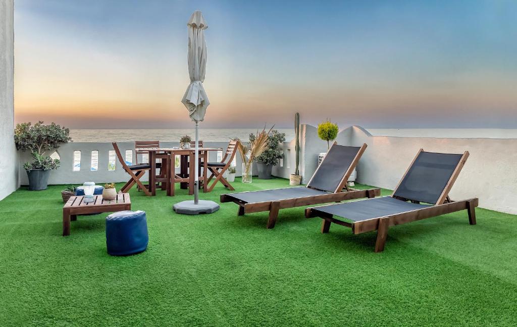 a patio with chairs and a table and grass at Star Apartments in Rethymno Town