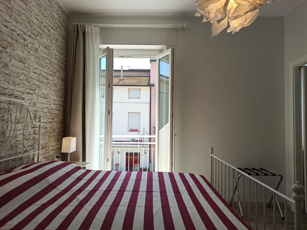 a bedroom with a striped bed and a large window at Colleoni 19 in Civitanova Marche