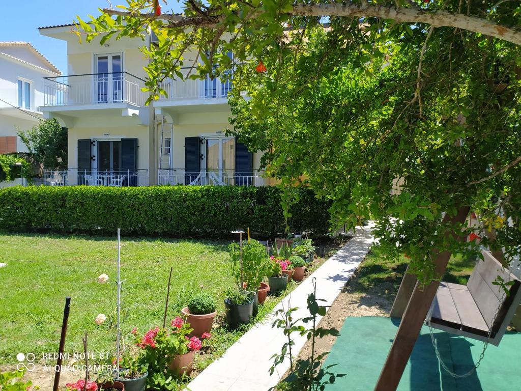 a garden in front of a house with potted plants at Elenas Garden in Kavos