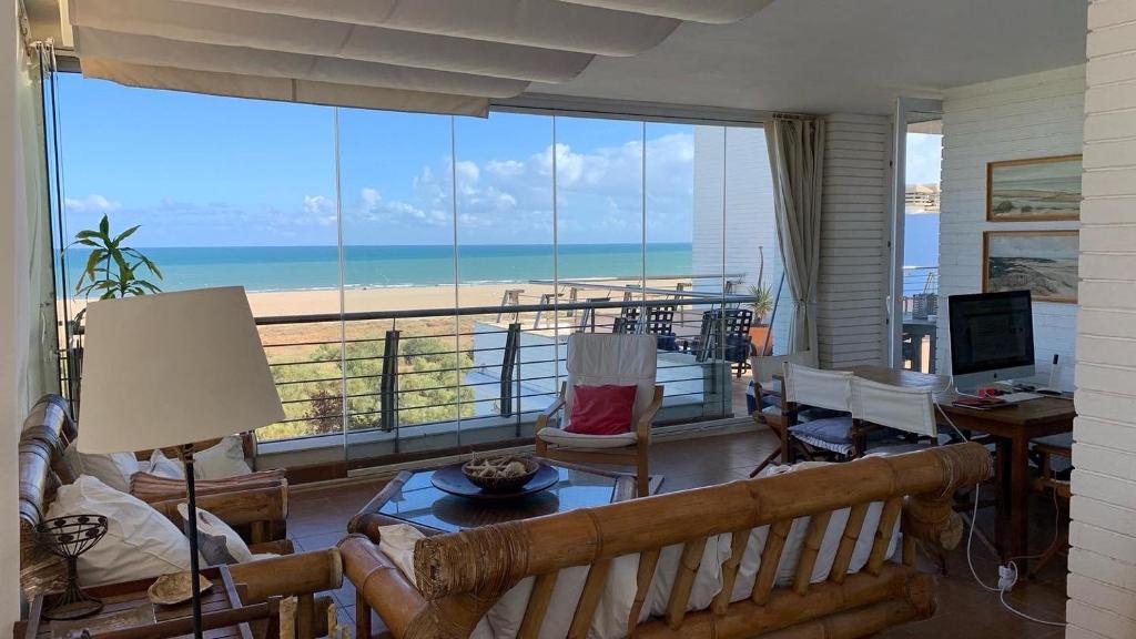sala de estar con vistas a la playa en Espectacular Atico Frente Al Mar, en Isla del Moral