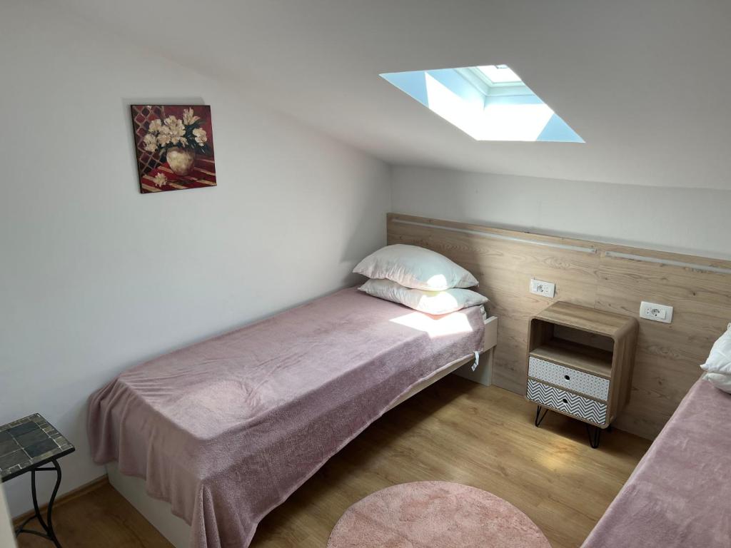 a small bedroom with a bed and a window at Apartments Vila Vino in Sveta Nedelja