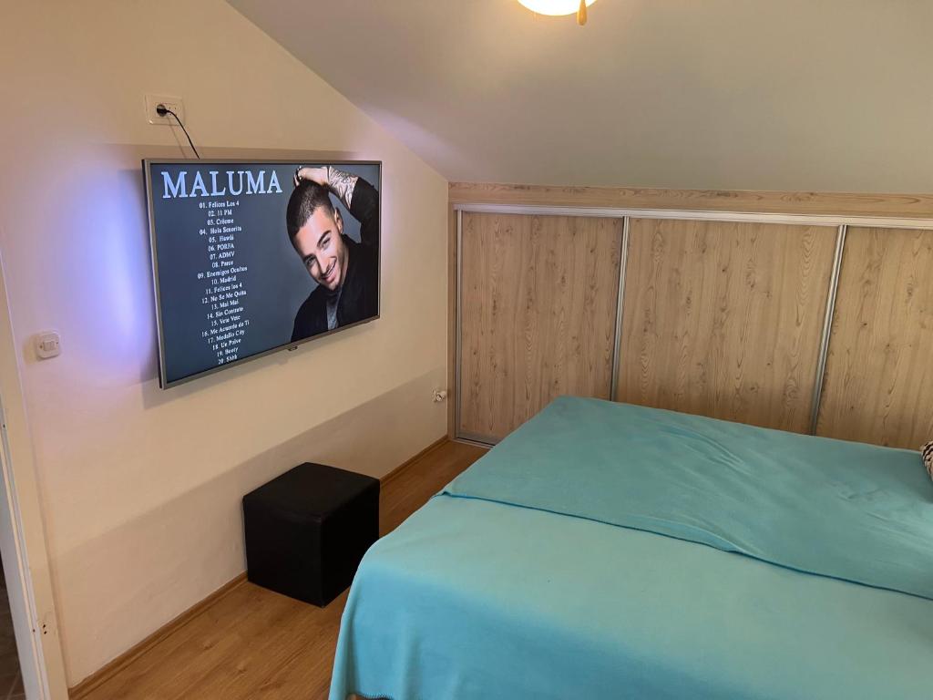 a bedroom with a bed and a sign on the wall at Apartments Vila Vino in Sveta Nedelja