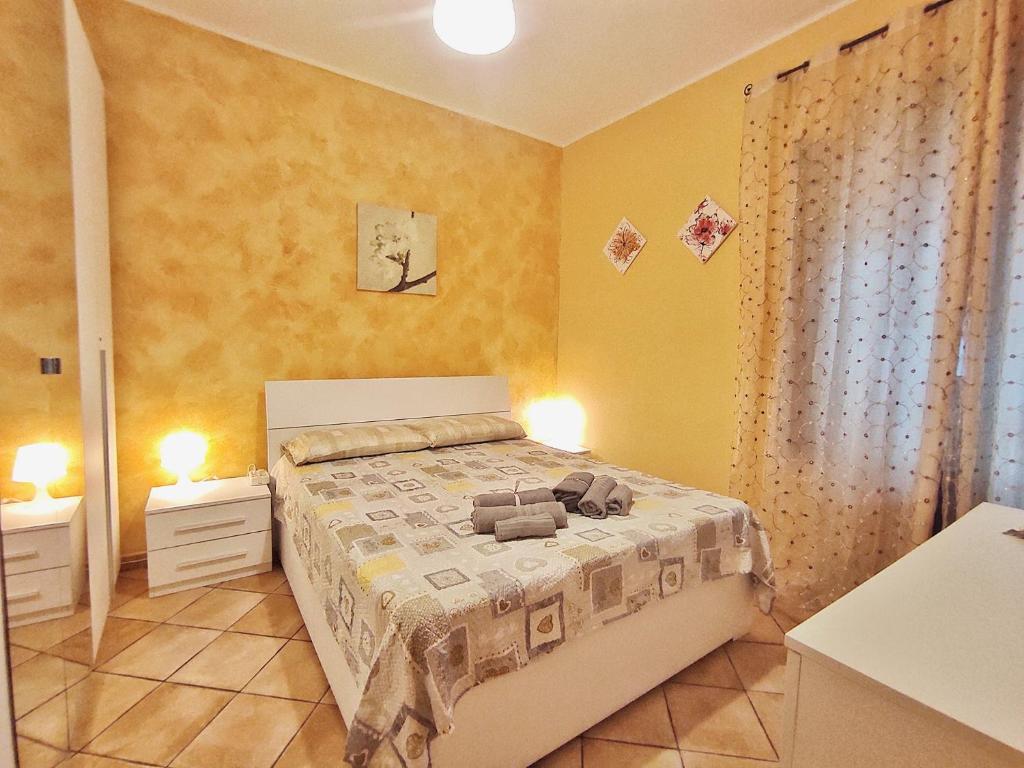 - une chambre avec un lit et des murs jaunes dans l'établissement Appartamento Aci Sant'Antonio, à Aci Catena