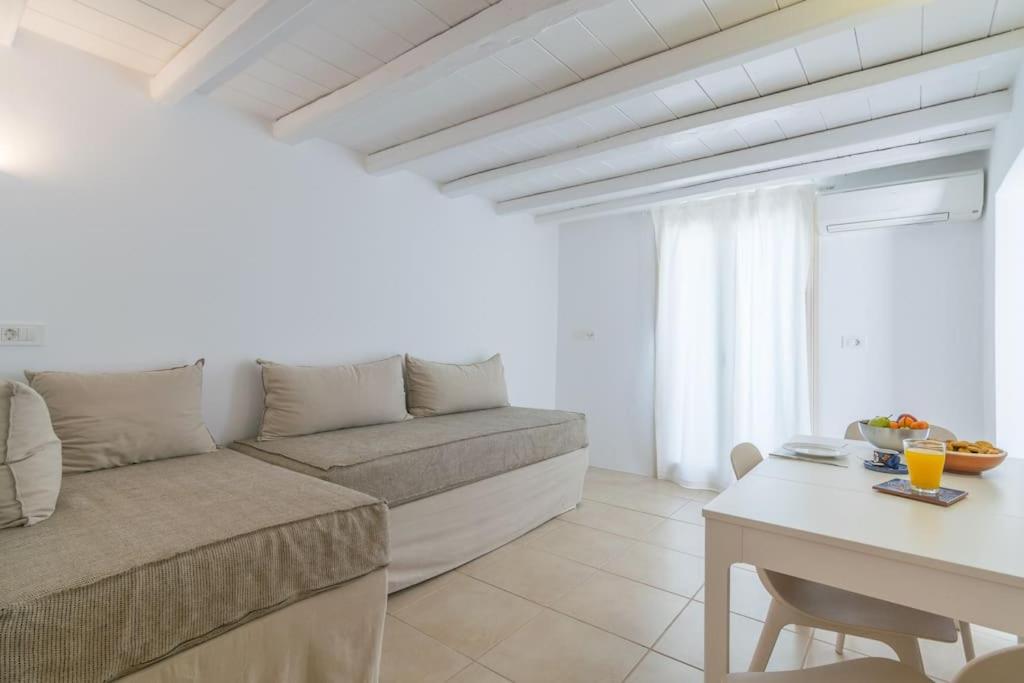 a living room with a couch and a table at Gazia Guesthouse Milos in Adamas