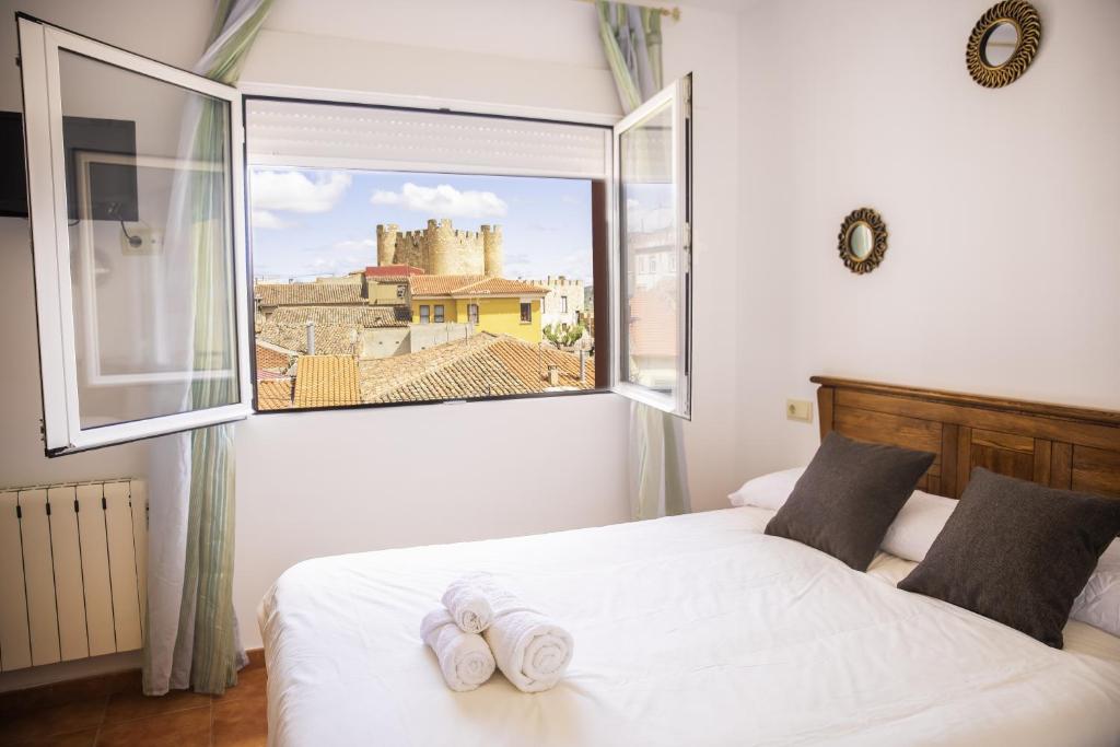 1 dormitorio con ventana grande y toallas en una cama en Casa Rural El Cabo, en Carcelén