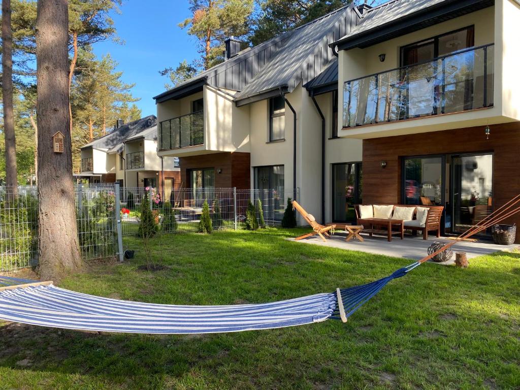 een hangmat in de tuin van een huis bij Domek Pod Sosnami in Rozewie